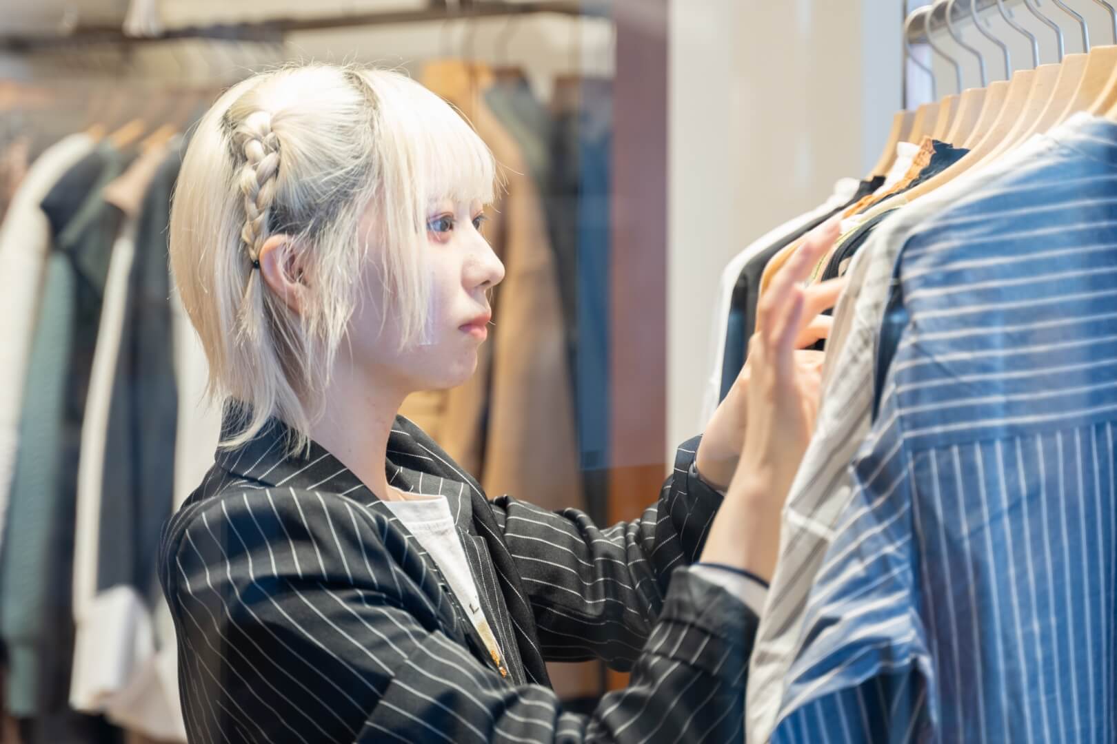 女性スタッフが商品の洋服を確認している様子