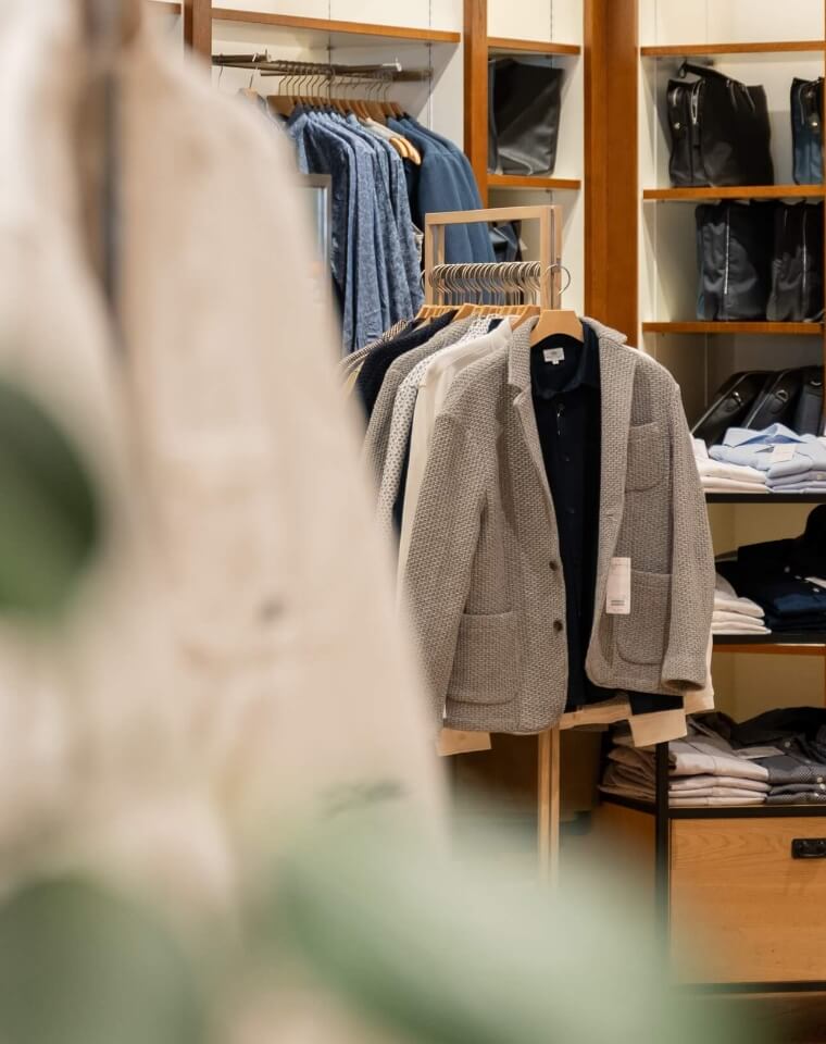 洋服がけにハンガーにかかった洋服が並んでいる様子